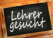 Das Bild zeigt eine Schultafel auf der steht "Lehrer gesucht".