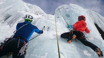 Zwei Kletterer mit Seilen in einem Gletscher