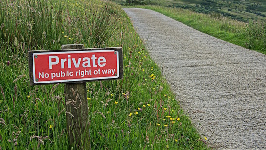 Ein rotes Schild am Straßenrand mit der Aufschrift: "Private. No public right of way".