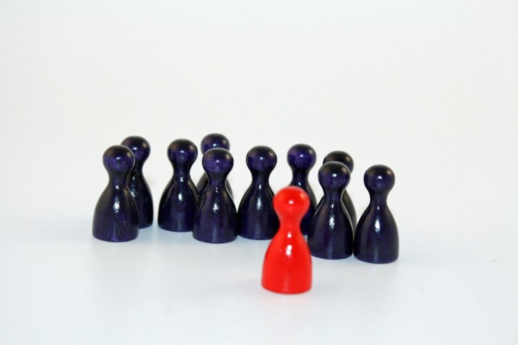 viele blaue und eine rote Spielfigur