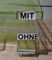 Das Bild zeigt eine beschriftete Ablagebox mit den Fächern "mit", "ohne" und "Datenschutz".