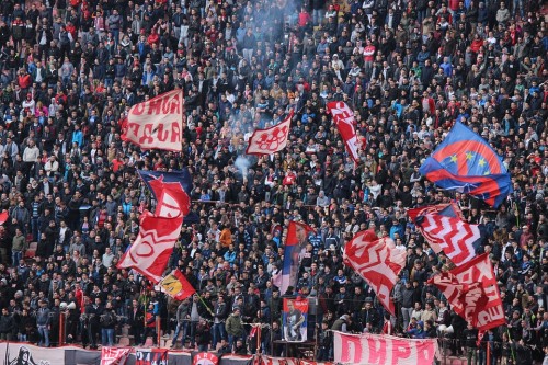 Tribüne in einem Fußballstadion mit Fans und Fahnen