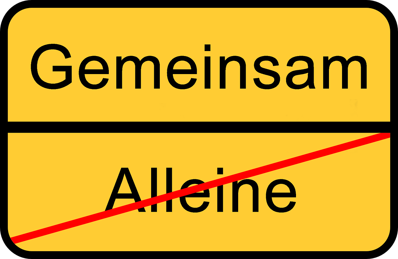 Das Bild zeigt ein Schild auf dem "Alleine" durchgestrichen ist und "Gemeinsam" das Neue anzeigt.